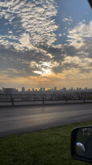 Golden sunrise captured over Iquique cityscape from moving vehicle