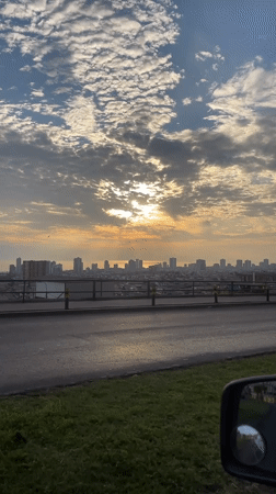 Golden sunrise captured over Iquique cityscape from moving vehicle