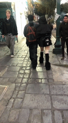 Two pedestrians walk cobblestone sidewalk in La Paz