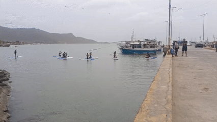 Paddleboarders enjoy calm waters in Juan Griego Bay, Venezuela