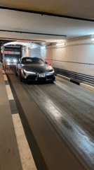 Gray Toyota Supra drives through illuminated car wash tunnel
