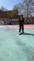Woman skateboards on colorful court in Barcelona park