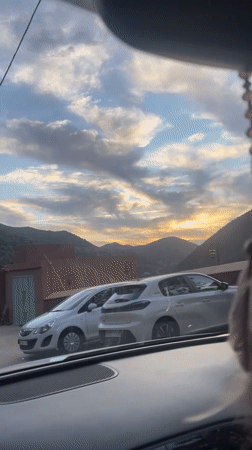 Driver records Moroccan castle buildings during evening journey near Asni