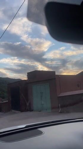 Driver records Moroccan castle buildings during evening journey near Asni