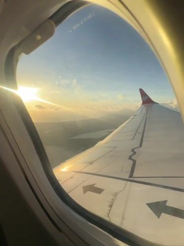 Passenger films sunrise sky view from airplane window near Kuta