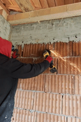 Worker grinds brick wall in Izgrev, Bulgaria