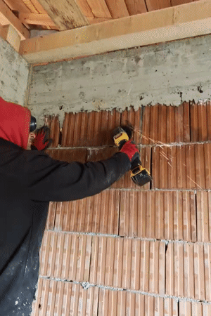 Worker grinds brick wall in Izgrev, Bulgaria