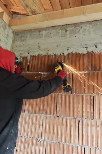 Worker grinds brick wall in Izgrev, Bulgaria