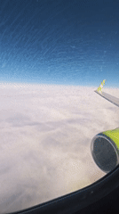 Passenger films cloudy skies from airplane window over Russia