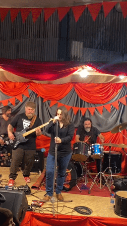 Band performs at outdoor gathering with campfire in Buenos Aires
