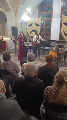 Indoor concert attended by dressed-up audience members