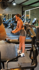 Woman adjusts cable machine equipment at Indonesian gym