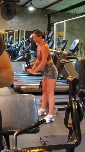 Woman adjusts cable machine equipment at Indonesian gym