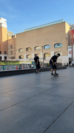 Skateboarders perform tricks at Barcelona plaza during evening session