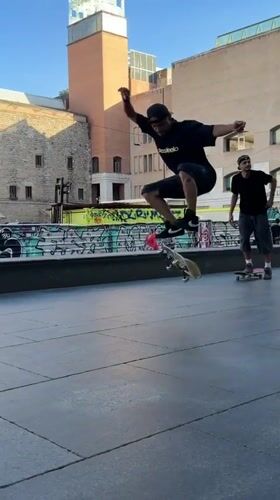 Skateboarders perform tricks at Barcelona plaza during evening session