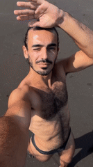 Man takes morning selfie on black sand beach in Indonesia