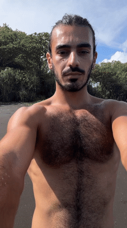 Man takes morning selfie on black sand beach in Indonesia