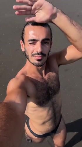 Man takes morning selfie on black sand beach in Indonesia