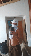 Masked individual takes selfies in El Espinal home