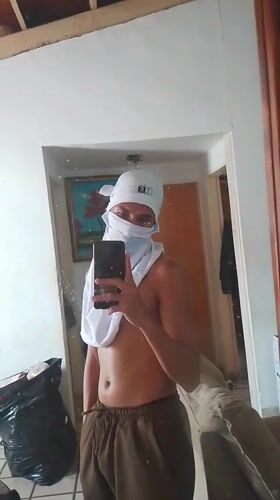 Masked individual takes selfies in El Espinal home