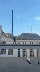 Man crosses pedestrian bridge between white buildings in Moscow