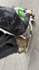 Two riders share Milan street on scooter and skateboard