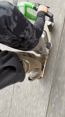 Two riders share Milan street on scooter and skateboard