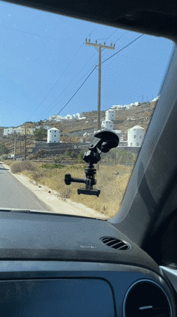 Driving past Santorini's white hillside buildings
