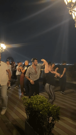Rooftop dancing under Baku city lights on a warm summer night