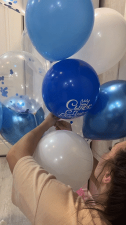 Woman arranges blue and white balloon bouquet in Cheboksary