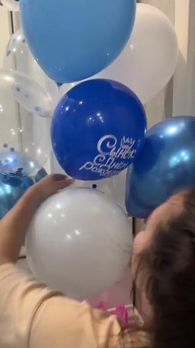 Woman arranges blue and white balloon bouquet in Cheboksary