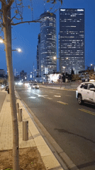 Evening skyscrapers illuminated during Tel Aviv dusk traffic scene