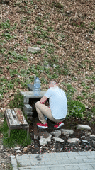 Man fills bottle at spring in Wisła, Poland