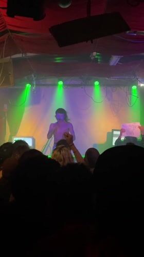 Concert performer with white makeup filmed by audience member