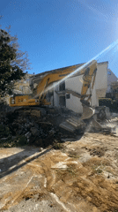 Excavator demolishes concrete wall at Bečići construction site