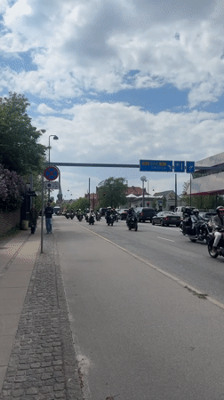 Motorcycle procession rides through Copenhagen streets in coordinated group