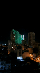 Green-lit modern building dominates Nha Trang nighttime cityscape