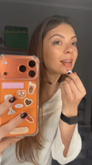 Woman records makeup routine with phone in Khimki