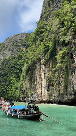 Tourist boats navigate scenic limestone cliffs in Ao Nang bay
