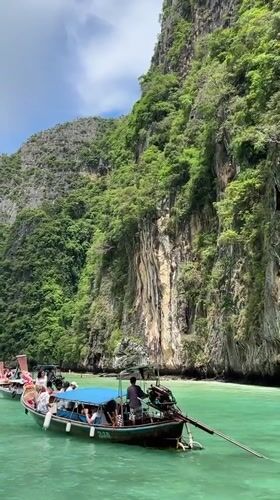 Tourist boats navigate scenic limestone cliffs in Ao Nang bay