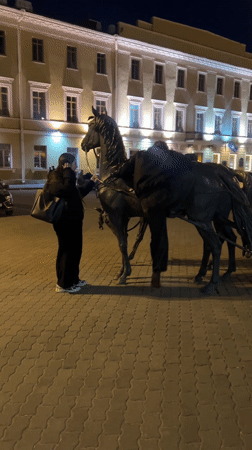 Evening street scenes and statue interactions documented in Minsk