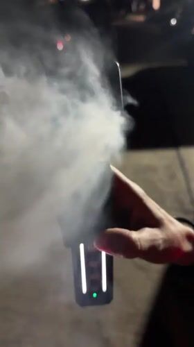 Person uses vapor-producing electronic device in Choeng Mon, Thailand