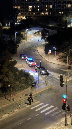 Tel Aviv rooftop dancing and street-level police activity, same night