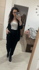 Woman takes smiling mirror selfie in professional attire