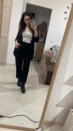 Woman takes smiling mirror selfie in professional attire
