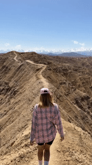 Woman hikes mountain ridge near Bokonbayevo, Kyrgyzstan