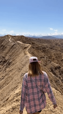 Woman hikes mountain ridge near Bokonbayevo, Kyrgyzstan