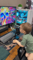 Toddler explores computer setup in Russian home office