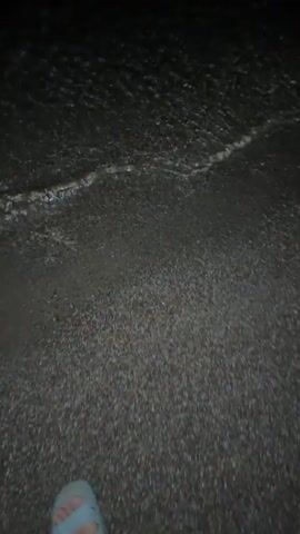 This short media file depicts a serene nighttime scene at a beach. The primary subjects are the tranquil waters of a lake or sea and the pebbly shore. The activity is passive; the waves gently lap against the shore, and the focus is on the natural beauty of the environment.

The time of day is clearly night, with a bright full moon dominating the sky. The moon's reflection creates a shimmering, illuminated path across the dark water, adding a magical quality to the scene. The weather appears calm, with no indication of wind or harsh conditions, contributing to the peaceful atmosphere.

The location cues suggest a beach setting, likely in a place with a large body of water. The pebbles on the shore are a notable detail, and the texture of the sand and water is subtly captured. The overall emotion evoked is one of tranquility, serenity, and natural beauty. There is no visible text in the media file.
