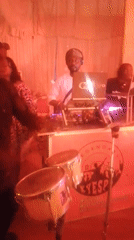 DJ performs at red-lit indoor event venue